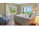 Comfortable bedroom with a balcony, natural light, and views of the lake and surrounding forest at 1555 Three Peaks Rd, Golden, CO 80403