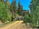 Rustic wooden gate leading to property; forest setting at 1555 Three Peaks Rd, Golden, CO 80403