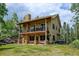 Inviting home with covered deck and patio, stone accents, and ample outdoor space for relaxation at 1555 Three Peaks Rd, Golden, CO 80403