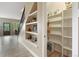 Hallway with custom shelves near the staircase and a peek into a pantry at 1555 Three Peaks Rd, Golden, CO 80403