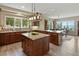 Open kitchen boasts granite counters, pendant lighting, custom cabinets, and views of the dining room at 1555 Three Peaks Rd, Golden, CO 80403