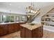 Beautiful kitchen with granite counters, custom cabinets, island, open to living room and staircase at 1555 Three Peaks Rd, Golden, CO 80403