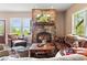 Inviting living room with a stone fireplace, hardwood floors, comfortable seating, and large windows offering outdoor views at 1555 Three Peaks Rd, Golden, CO 80403