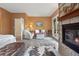 Cozy main bedroom featuring a stone fireplace, wood floors, comfortable seating, and a walk-out balcony at 1555 Three Peaks Rd, Golden, CO 80403
