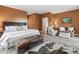 Relaxing main bedroom boasts a leather ottoman, light wood floors, and a picture window at 1555 Three Peaks Rd, Golden, CO 80403
