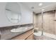 Modern bathroom with tiled shower and glass door, vanity with sink and large round mirror at 24763 E Crestridge Pl, Aurora, CO 80016