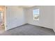 White bedroom with grey carpet, one window, and a white door at 24763 E Crestridge Pl, Aurora, CO 80016