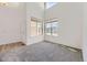 Bright living room with high ceilings, large windows, and neutral carpet at 24763 E Crestridge Pl, Aurora, CO 80016