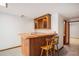 Basement wooden bar with sink, countertop, wine rack, and two chairs at 7965 Lakeshore Dr, Parker, CO 80134