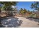 Outdoor basketball court with a hoop and wooden fence, surrounded by mature trees and landscaping at 7965 Lakeshore Dr, Parker, CO 80134
