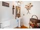 Elegant powder room with pedestal sink, hardwood floor, and decorative wall art at 7965 Lakeshore Dr, Parker, CO 80134