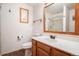 Bathroom showcasing wood-framed mirror, single sink vanity, toilet, and tiled shower with glass door at 7965 Lakeshore Dr, Parker, CO 80134