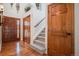 Inviting entryway with hardwood floors, decorative doors, and a staircase leading to the upper level at 7965 Lakeshore Dr, Parker, CO 80134