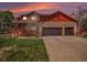 Charming two-story home featuring a stone facade, attached garage, covered porch, and well-maintained lawn at 7965 Lakeshore Dr, Parker, CO 80134