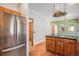 View of the kitchen island with wood cabinets, opening to the dining and living areas at 7965 Lakeshore Dr, Parker, CO 80134