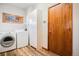 Functional laundry room with washer, dryer, storage cabinet, and exterior door at 7965 Lakeshore Dr, Parker, CO 80134