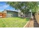 Spacious backyard with green lawn, mature trees, and a garden bed, offering a serene outdoor space at 2310 S Decatur St, Denver, CO 80219