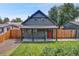 Charming craftsman home with a gray exterior, red door, and landscaped lawn at 2310 S Decatur St, Denver, CO 80219