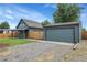 Exterior showcasing the home's siding, detached garage, and driveway at 2310 S Decatur St, Denver, CO 80219
