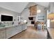 Open-concept living room with vaulted ceilings, wood floors, and a dining area adjacent to the kitchen at 2310 S Decatur St, Denver, CO 80219