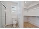 Well-lit bathroom with a glass-enclosed shower, a toilet, and an adjacent walk-in closet with ample shelving at 681 N Tempe St, Aurora, CO 80018
