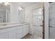 Bathroom featuring a double vanity with undermount sinks, a large mirror, and a shower in the background at 681 N Tempe St, Aurora, CO 80018