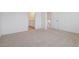 Spacious carpeted bedroom showcasing an ensuite bathroom and a door, creating a comfortable and private retreat at 681 N Tempe St, Aurora, CO 80018