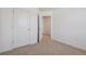 A bright, carpeted bedroom with white walls and two doorways, providing easy access to other areas of the home at 681 N Tempe St, Aurora, CO 80018