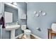 Charming powder room with pedestal sink, floral wall decor, and stylish blue paint at 14672 Melco Ave, Parker, CO 80134