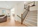 Inviting entryway with carpeted stairs, hardwood floors, and views into the living and dining areas at 14672 Melco Ave, Parker, CO 80134