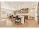 Open kitchen features an island with seating, modern appliances, and wood floors at 14672 Melco Ave, Parker, CO 80134