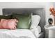 This bedroom has a gray headboard, throw pillows and blankets with a vase on a white table at 4280 S Pearl St, Englewood, CO 80113
