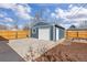 View of a detached one-car garage, featuring a white door and adjacent garden boxes at 4280 S Pearl St, Englewood, CO 80113