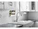 Bright kitchen with stainless steel faucet, white cabinets, modern backsplash, and granite countertops at 4280 S Pearl St, Englewood, CO 80113
