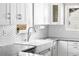 Close up of kitchen features a large farmhouse sink, granite countertops, and hexagon tile backsplash at 4280 S Pearl St, Englewood, CO 80113