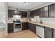 Updated kitchen featuring stainless steel appliances, dark cabinetry, and light countertops at 1185 Worchester St, Aurora, CO 80011