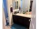 Bathroom featuring double sinks, dark wood cabinets, and ample counter space, providing functionality and style at 15600 Bolling, Denver, CO 80239