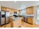 Bright kitchen features stainless steel appliances, a center island and light wood cabinetry at 22030 Hill Gail Way, Parker, CO 80138