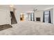 Spacious open-concept living room showcasing plush carpeting, a fireplace, and a staircase to the upper level at 22030 Hill Gail Way, Parker, CO 80138