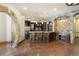 Basement bar area featuring stone arch and rustic wood design at 3120 Bears Den Dr, Sedalia, CO 80135
