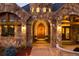 Stunning castle-style home entrance with arched wooden door, stone accents, and manicured landscaping at 3120 Bears Den Dr, Sedalia, CO 80135