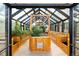 Interior view of a bright greenhouse with raised wooden planters and a clear glass roof at 3120 Bears Den Dr, Sedalia, CO 80135