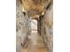 Stone hallway with arched ceiling and tiled floors leads to a bright stairway at 3120 Bears Den Dr, Sedalia, CO 80135