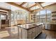 Bright, open kitchen with a large island, stone accents, and ample natural light from large windows at 3120 Bears Den Dr, Sedalia, CO 80135