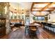 Open-concept kitchen and dining area with wood beams, stone accents, and plenty of natural light at 3120 Bears Den Dr, Sedalia, CO 80135