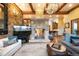Cozy living room with a stone fireplace, comfortable seating, hardwood floors, and a large area rug at 3120 Bears Den Dr, Sedalia, CO 80135