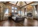 Spacious main bedroom featuring hardwood floors, stone walls, fireplace, and wood beam ceiling at 3120 Bears Den Dr, Sedalia, CO 80135