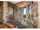 Stone stairway with wood trim and ornate light fixture at 3120 Bears Den Dr, Sedalia, CO 80135