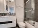 Bathroom featuring gray tile, modern fixtures, and a glass shower enclosure with bright lighting at 338 Saint Paul St, Denver, CO 80206