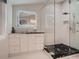 Modern bathroom featuring black countertops, glass shower, and a stylish, illuminated mirror at 338 Saint Paul St, Denver, CO 80206